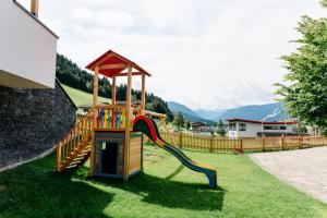 un parque infantil con un tobogán en un patio en Landhotel Berger en Eben im Pongau