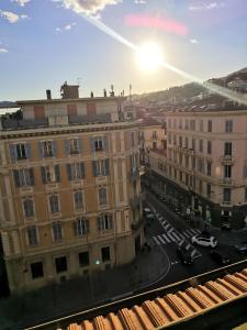a view of a city with buildings and the sun at One bedroom appartement at Sanremo 40 m away from the beach with sea view furnished terrace and wifi in Sanremo