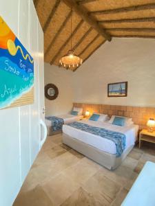a bedroom with two beds and a chandelier at Vilarejo Macapá Chalés in Luis Correia