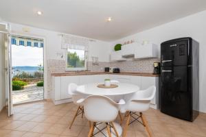 a kitchen with a white table and a black refrigerator at Villa Bella Vista - apartments in Labin