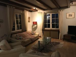 sala de estar con sofá y mesa en le gîte de la Tourette, en Hohrod