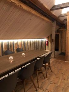 a table and chairs in a room with a wooden wall at Storbo Adventure Camp in Storbo