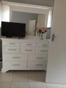 a large white dresser with a television and a mirror at 19 Mirabelle Place in Pietermaritzburg