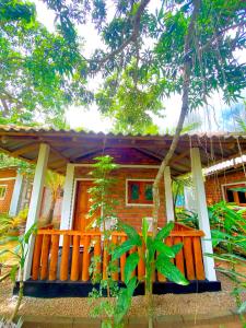 ein Haus mit einer Holzveranda davor in der Unterkunft Isuru Cabanas and Restaurant in Tangalle