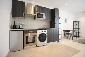 a kitchen with a washing machine and a microwave at APARTMENTS GH - Accra - Cantonments - Embassy Gardens in Accra