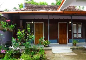 a small house with flowers in front of it at Royal Holidays in Alleppey