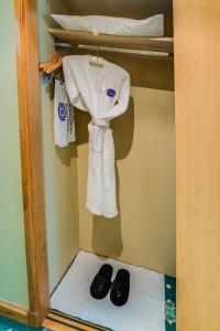 a closet with a pair of shoes and towels at Grand Continental Hotel in Abu Dhabi