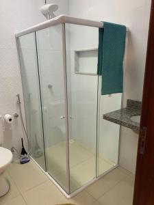 a glass shower in a bathroom with a toilet at Suíte Peixe Espada in Praia do Forte