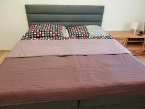 łóżko z fioletową kołdrą i poduszkami w obiekcie Apartment in city center w Karlowych Warach