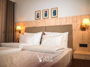 1 dormitorio con 2 camas y almohadas blancas en Vila Park Bujtina en Prizren