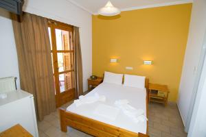 Un dormitorio con una cama blanca con toallas. en Hotel Aidipsos en Loutra Edipsou