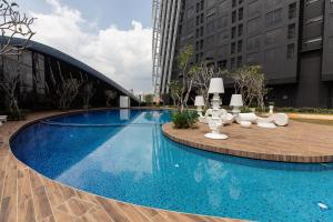 einen großen blauen Pool mit einem Tisch und Stühlen in der Unterkunft Near MITEC, Arte Mont Kiara by Cobnb in Kuala Lumpur