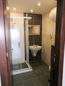 a bathroom with a sink and a shower at Dair Ghbar Gate Apartments in Amman