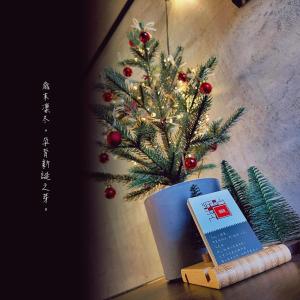 un arbre de Noël dans un vase avec un livre dans l'établissement Wave Weaver B&B, à Chenggong