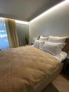 ein Schlafzimmer mit einem großen Bett mit weißen Kissen und einem Fenster in der Unterkunft Sadyba Lisova in Ternopil