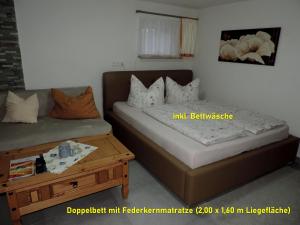 two beds in a room with a wooden table at DIE Ferienwohnung - Wittenberg an den Elbwiesen in Lutherstadt Wittenberg