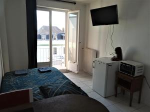 a bedroom with a bed and a television and a window at APPARTEMENT PROCHE GARE ET CENTRE VILLE in Melun