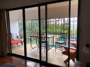 a room with sliding glass doors with a table and chairs at Cockatoo Studio Apartments in Manuel Antonio