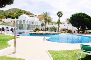 a large swimming pool in a resort with palm trees at Villa Nerja Views Mediterranean Panorama in Nerja