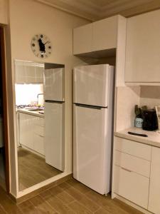 uma cozinha com um frigorífico branco e um relógio na parede em Lovely Escape House in a Frame with Garden em Istambul