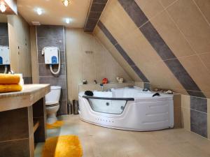 ein Badezimmer mit einer großen Badewanne und einem WC in der Unterkunft Bajeczny Wypoczynek Apartamenty in Witów