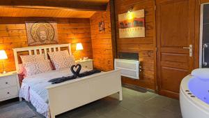 een slaapkamer met een bed met een wastafel en een bad bij Au chalet d'Isa in Havelange