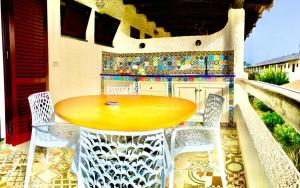 una mesa y sillas en un patio con una pared de mosaico en Apartment Suite residence al porto Vulcano, en Vulcano