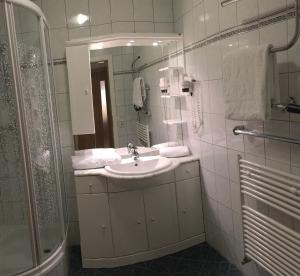 a white bathroom with a sink and a shower at Apartment Sara in Ausserfragant +13 photos