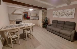 a living room with a couch and a table and a christmas tree at Il borghetto in Fanano
