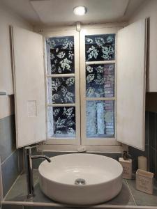 a white sink in a bathroom with a window at Il borghetto in Fanano