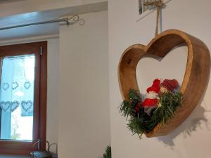 une couronne en forme de cœur est suspendue sur un mur dans l'établissement Il borghetto, à Fanano