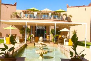 a hotel with a fountain in front of a building at Villa Kesh Evasion Marrakech in Marrakesh