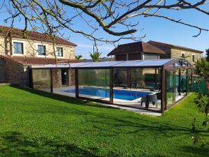 a glass house with a swimming pool in a yard at Casa Bama in Bama