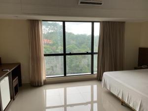 a bedroom with a bed and a large window at Tropical Executive Hotel flat in Manaus