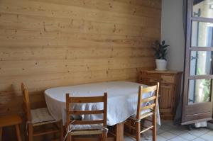 einen Tisch und Stühle in einem Zimmer mit einer Holzwand in der Unterkunft 4P - Ski Villard-Reculas domaine Alpe d'Huez in Villard-Reculas + 2 Fotos