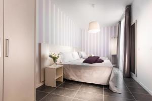 ein Schlafzimmer mit einem Bett und einem Tisch mit Blumen darauf in der Unterkunft Hotel Star in Cesenatico