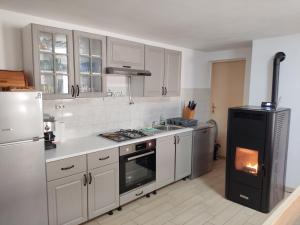 a kitchen with white cabinets and a stove top oven at Kuća za odmor "Seka"*** in Mrkopalj
