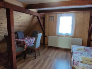 uma sala de jantar com uma mesa e cadeiras e uma janela em Kuća za odmor "Seka"*** em Mrkopalj