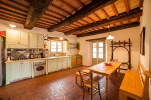 une grande cuisine avec une table en bois et une salle à manger dans l'établissement Podere Tepolino, à Castel del Piano