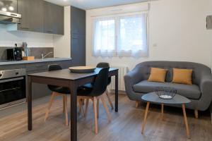 サン・ブリューにあるBel appartement idéalement placé Saint-Brieuc, wifi, parking gratuitのキッチン、リビングルーム(テーブル、ソファ付)