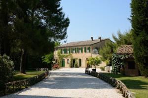 a large stone house with a driveway at Villa Tombolina in Montemaggiore al Metauro