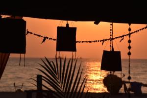 a sunset with clotheslines with silhouettes of the ocean at Sonho do Mar in Agonda