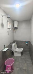 La salle de bains est pourvue de toilettes et d'un seau rose. dans l'établissement Krish Garden, à Chidambaram