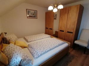 1 dormitorio con 2 camas individuales y 1 silla en Ferienhof Kehlbauer en Hof bei Salzburg