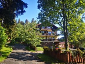 um edifício com varandas e uma cerca ao lado de uma estrada em Apartament pod Świerkami em Szklarska Poręba