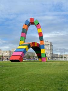 a colorful arch in the middle of a field at Vivez Le Centre ville à la Plage - Balcon in Le Havre