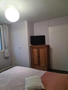 a room with a television and a bed at Private room in Beauvais