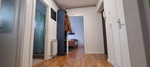 a hallway with blue and white walls and wooden floors at Dino's spacious place in Sarajevo
