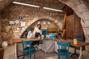 a woman and child sitting at a table in a stone room at Albergo Diffuso Monopoli in Monopoli
