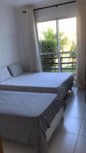 a bedroom with a bed and a large window at Reserva Imbassai - Vila dos Lírios - Natureza e Descanso in Imbassai +19 photos
